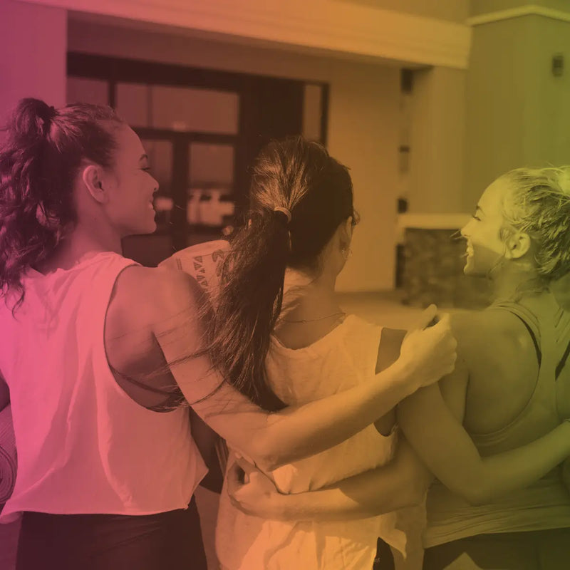 Three active young women walking together with their arms around each other