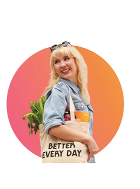 Female carrying canvas shopping tote bag on shoulder with groceries and a Playtex box showing